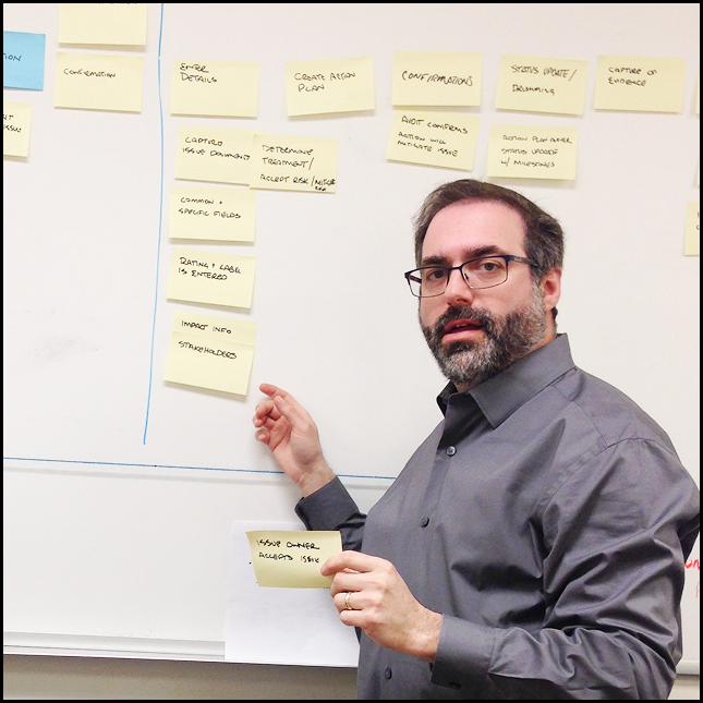 vignette of card sorting exersize with Dave Lumerman standing in front of a whiteboard
