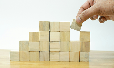Decorative leadership photo of hand stacking bricks